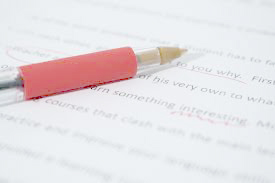 Red pen correcting text: Knowing when to hyphenate.