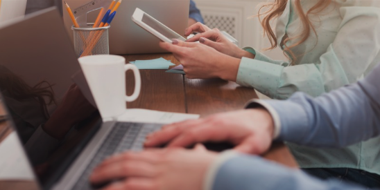 People working with a mug on desk